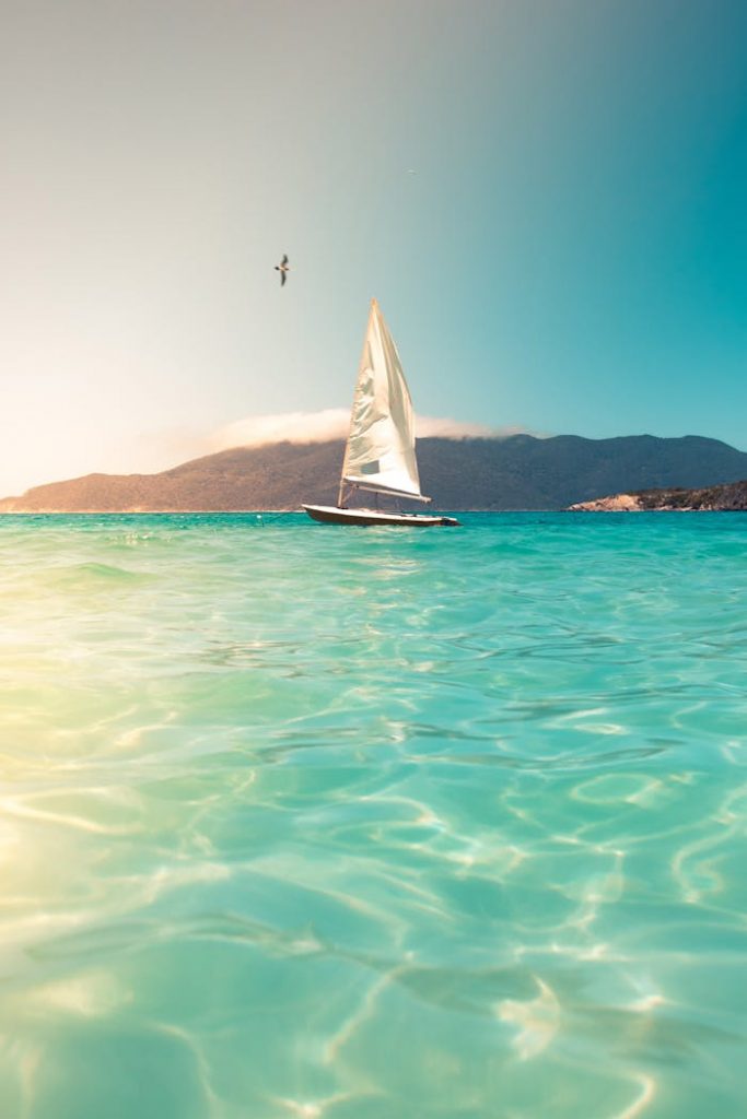 Crafting Captivating Headlines: Your awesome post title goes here A sailboat glides across turquoise seas beneath a clear sky, ideal for tranquil travel and vacation scenes.