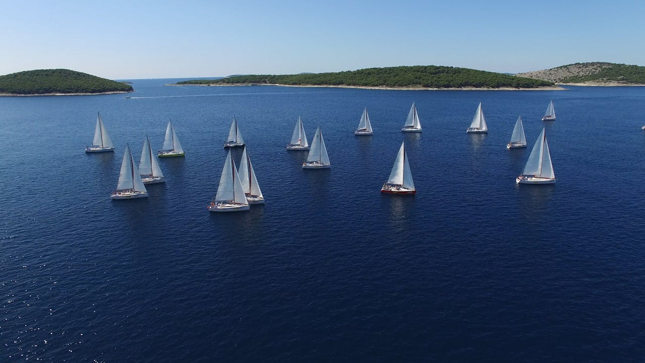 The Art of Drawing Readers In: Your attractive post title goes here Sailboats racing in a summer regatta on a clear blue ocean surrounded by islands.